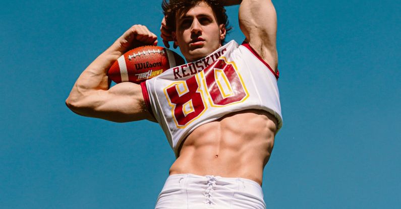Strength-to-weight - Low Angle Shot of a Muscular Athlete with an American Football Ball