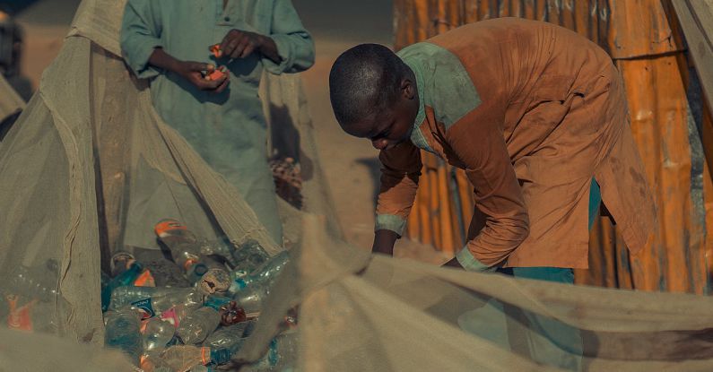 Recycling Composites - Two men are working on a pile of trash