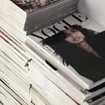 Smart Composites - High angle many fashion magazines stacked on floor against white brick wall in studio