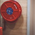 Fire Safety - Red Fire Extinguisher below Hose Reel
