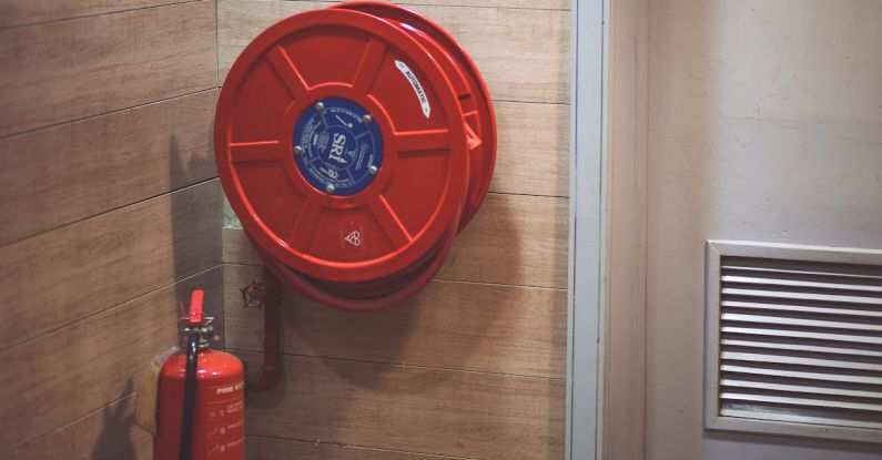 Fire Safety - Red Fire Extinguisher below Hose Reel